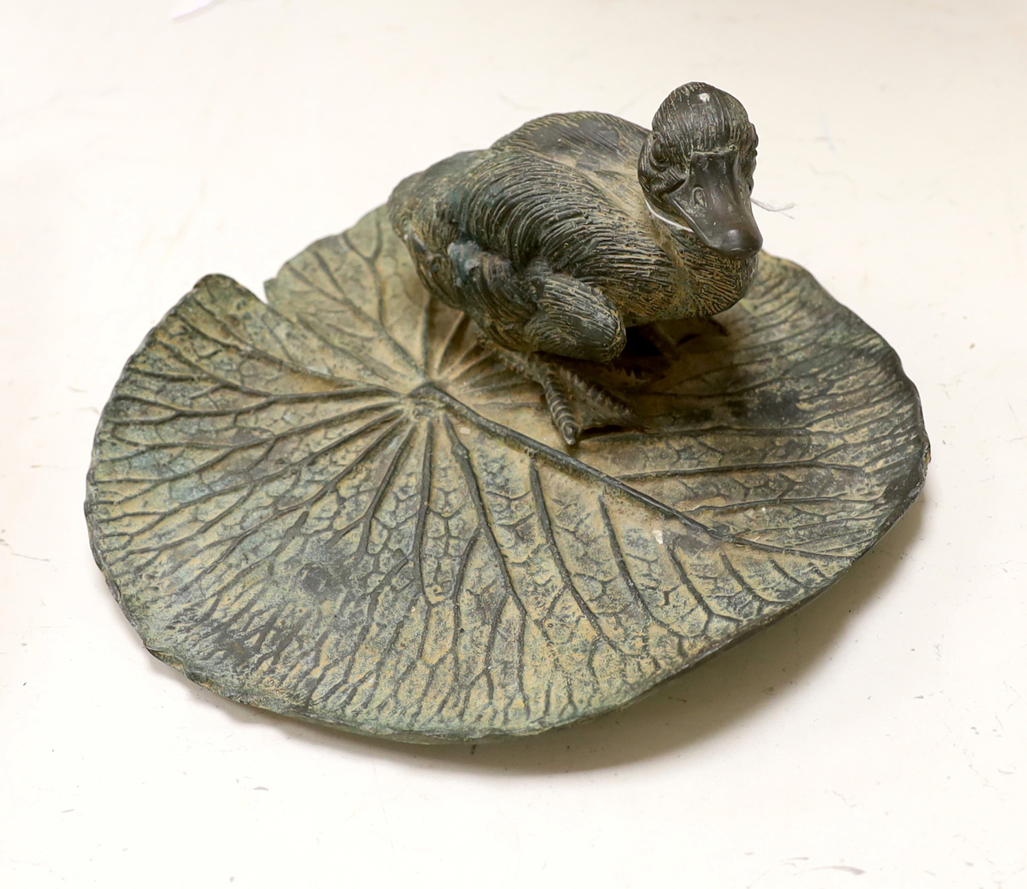A bronze model of a duck on a lily pad, 23cm wide